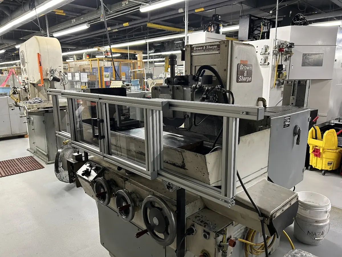 Brown & Sharpe surface grinder fitted with a custom aluminum-frame safety guard by 9EHS
