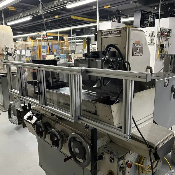 Brown & Sharpe surface grinder fitted with a custom aluminum-frame safety guard