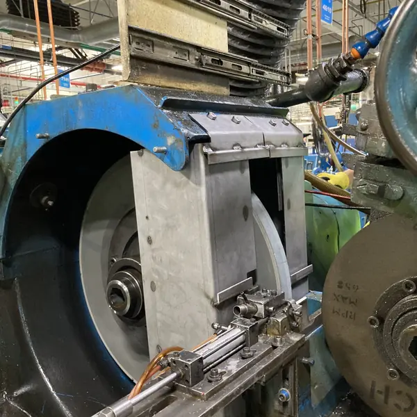 Cincinnati centerless grinder with a steel guard between the grinding wheels