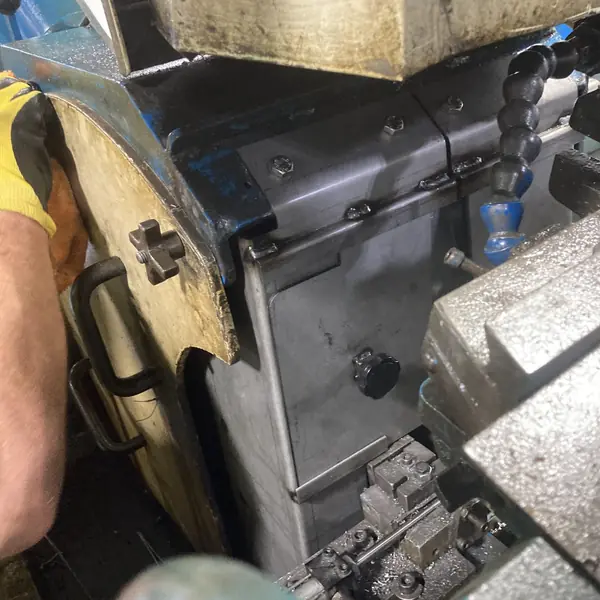 Steel guard enclosing the work area of a Cincinnati centerless grinder