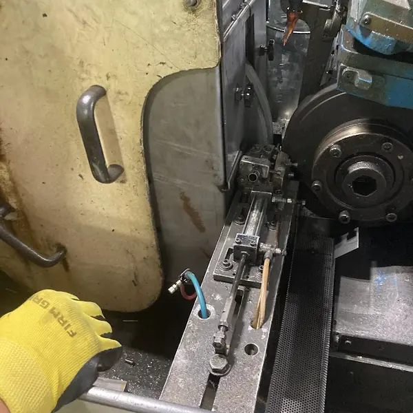 Hinged steel guard with a handle on a Cincinnati centerless grinder