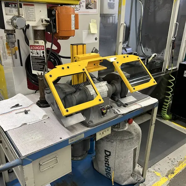 Dayton bench grinder fitted with yellow-frame clear eye shields