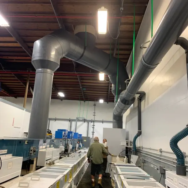 Row of dip tanks with grey PVC exhaust ductwork overhead