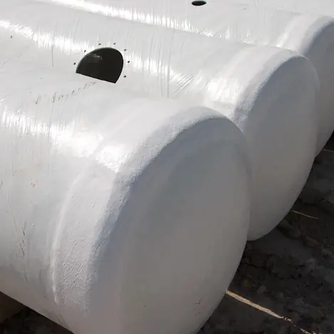 Row of horizontal FRP fiberglass tanks with flanged openings