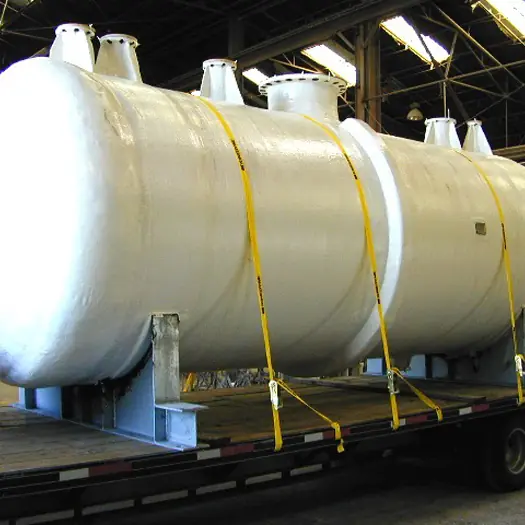 Large horizontal FRP vessel strapped to a flatbed trailer for delivery