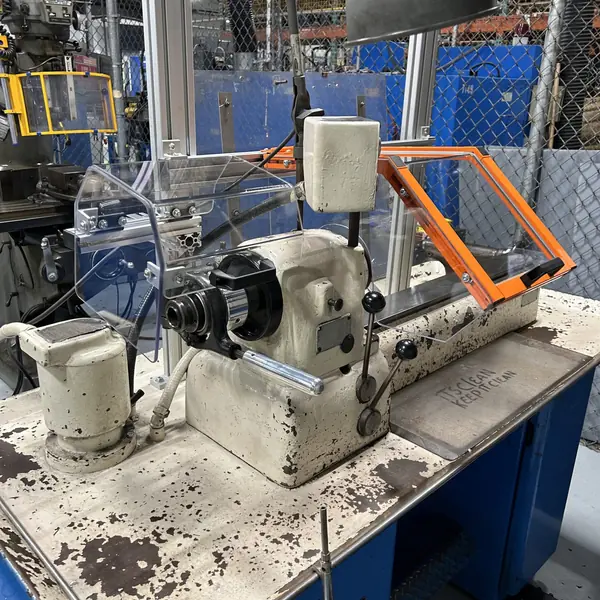 Hardinge lathe with a clear chuck shield and orange-frame guard