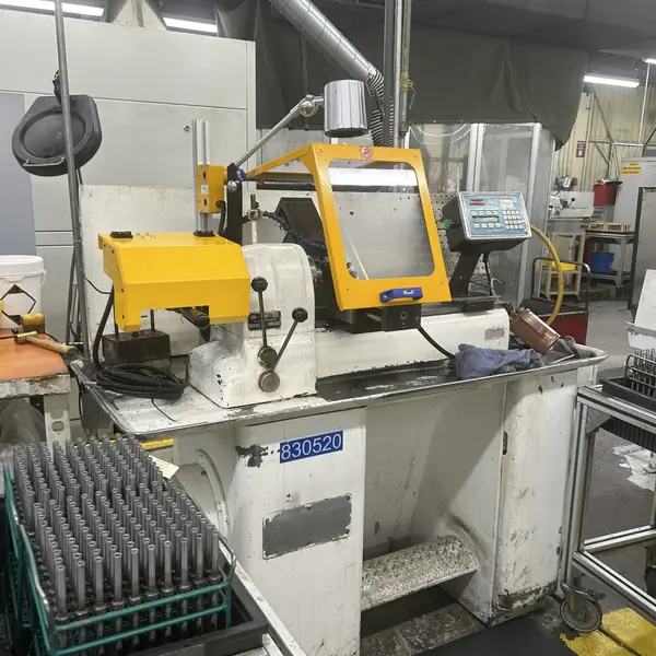 Hardinge lathe with a yellow headstock cover and yellow-frame chuck shield