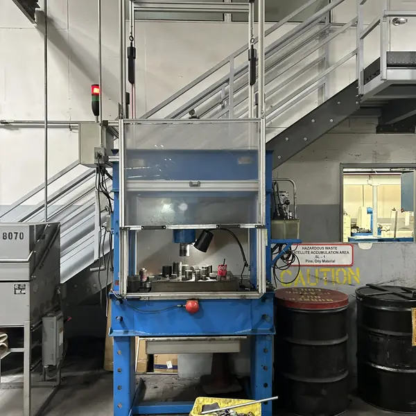 Blue H-frame hydraulic press fitted with a tall clear sliding guard