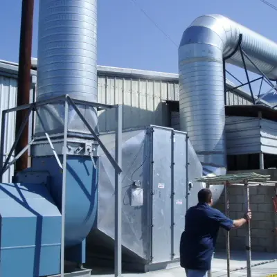 Industrial ventilation system with tall exhaust stacks being installed outside a plant