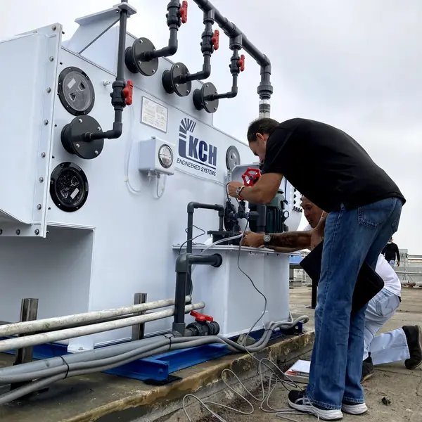 Technicians wiring and commissioning a KCH fume scrubber on a rooftop