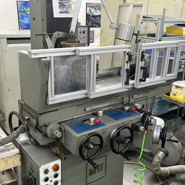 MHT surface grinder with a clear aluminum-frame table guard