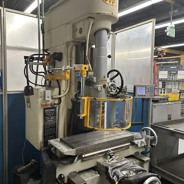 Moore jig boring mill fitted with a yellow-frame clear spindle shield