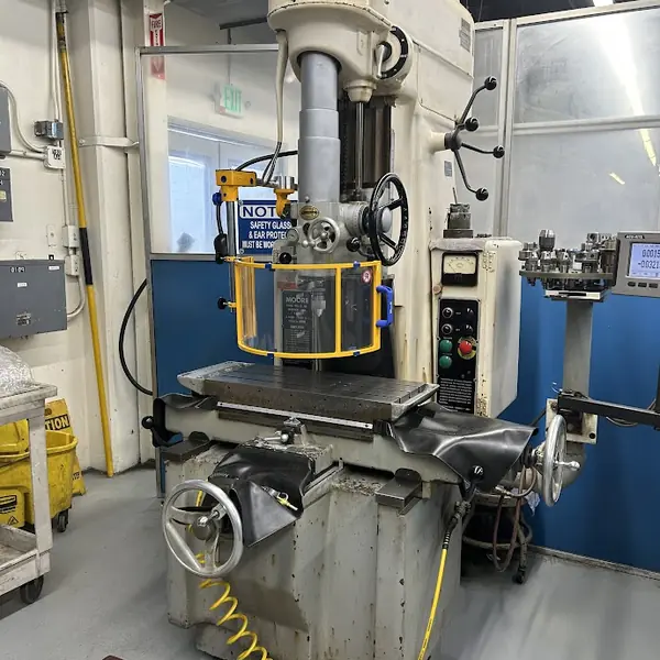 Front view of a Moore jig boring mill with a yellow-frame spindle shield