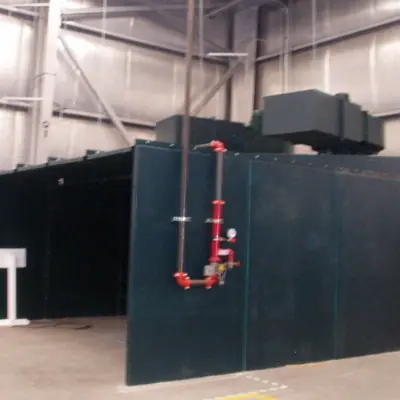 Large dark green process enclosure with a red sprinkler riser