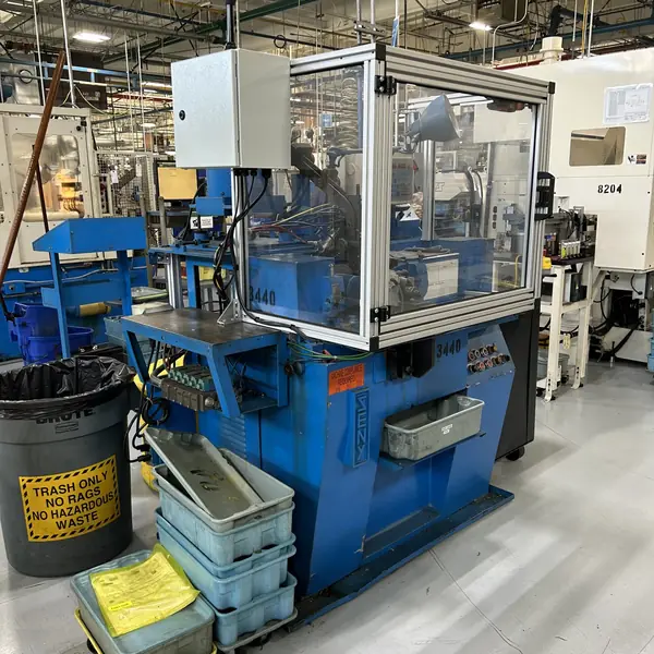 Seny grinder enclosed in an aluminum-frame guard with clear panels and a control box
