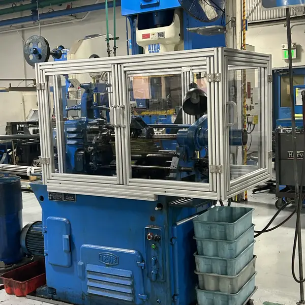 Traub lathe enclosed by a clear aluminum-frame guard