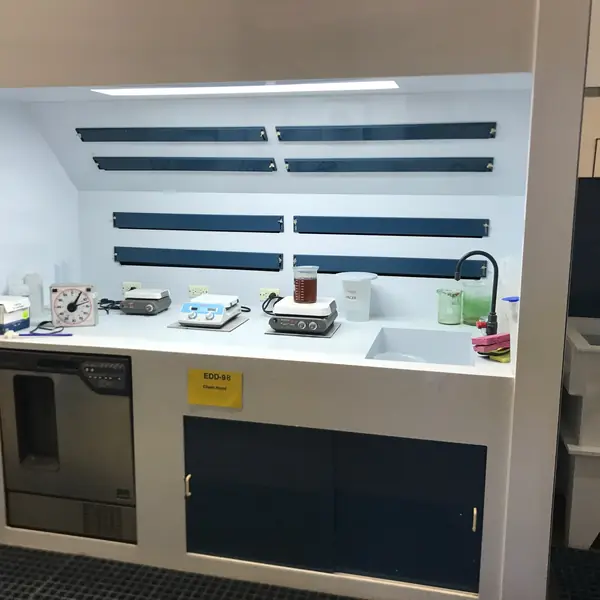 White polypropylene wet bench with a sink, navy cabinets and lab equipment