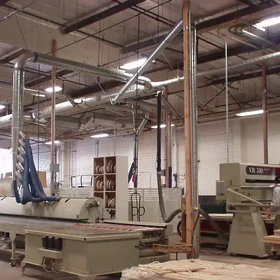 Overhead dust collection ducting over woodworking machines in a shop