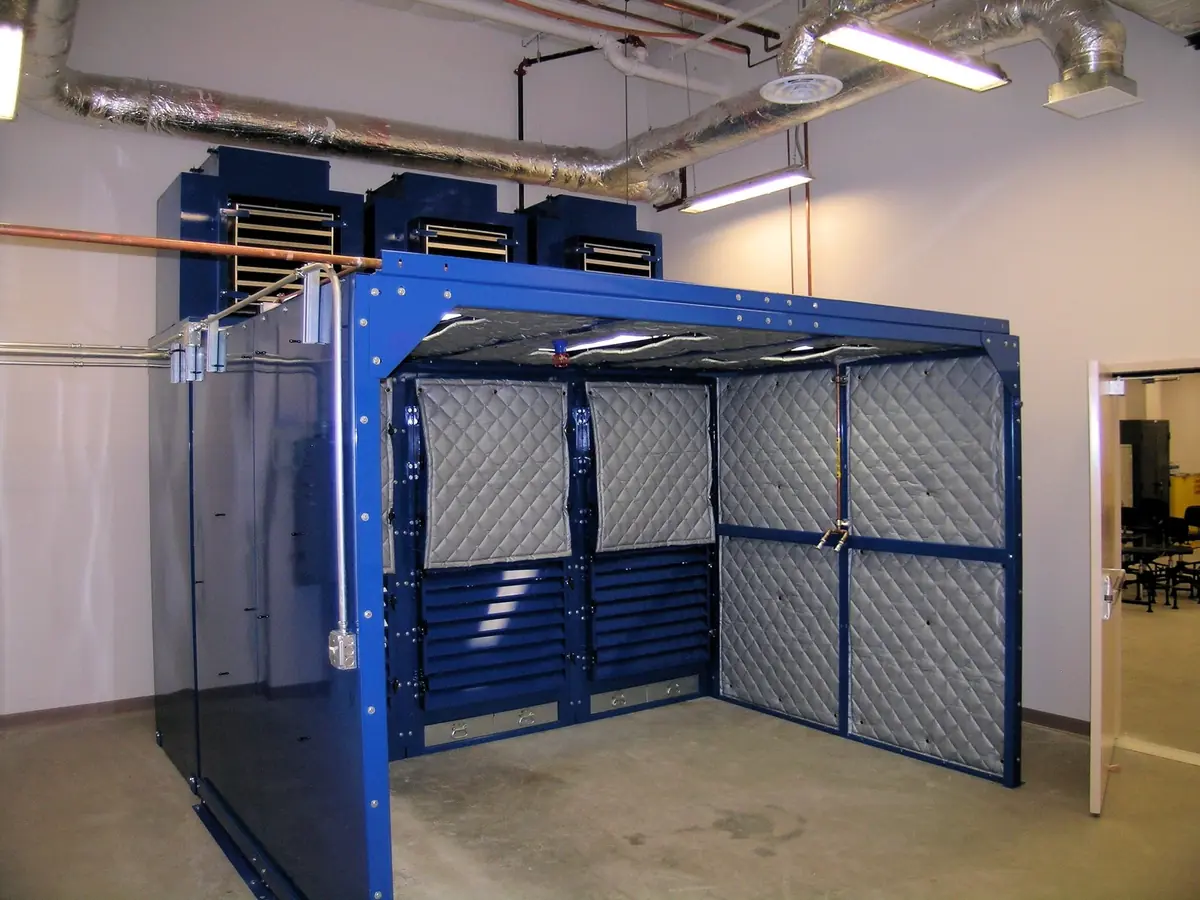 Blue-frame HEPA filtration enclosure with quilted acoustic panels in a clean shop